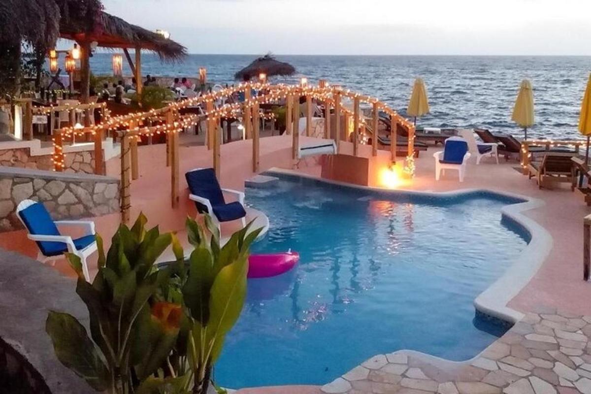 una piscina in un resort con sedie e luci