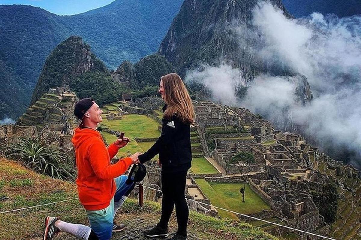 Un hombre y una mujer se dan la mano en la cima de una montaña