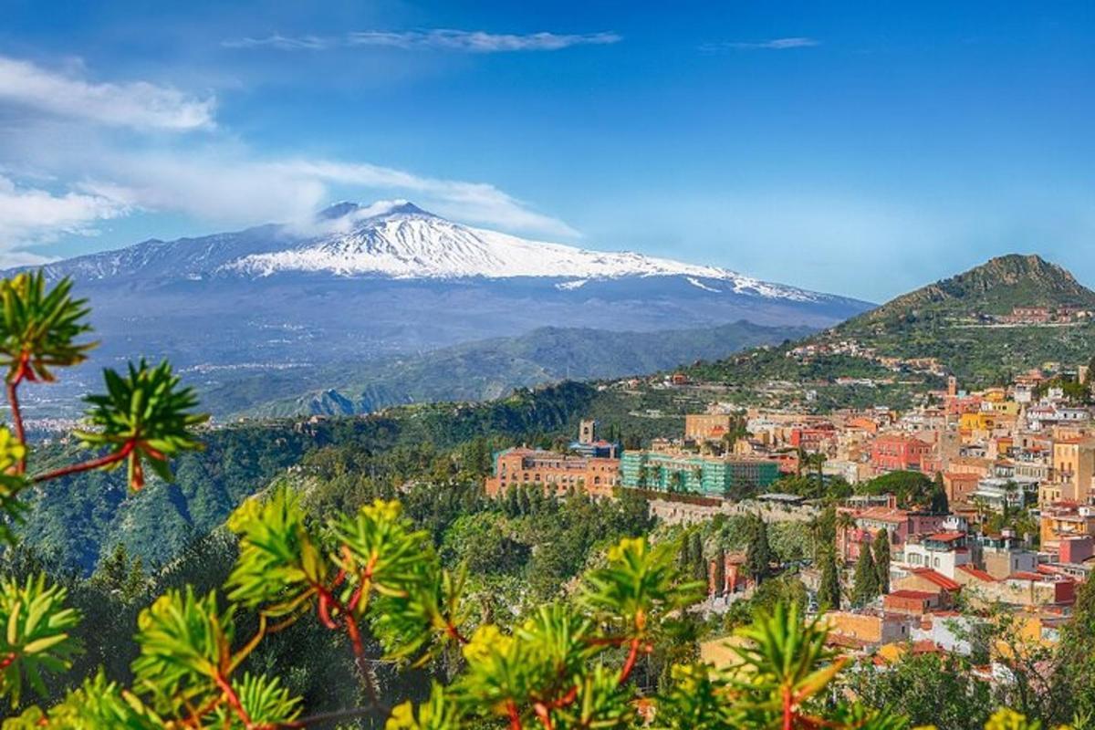 uma vista de uma montanha coberta de neve com uma cidade