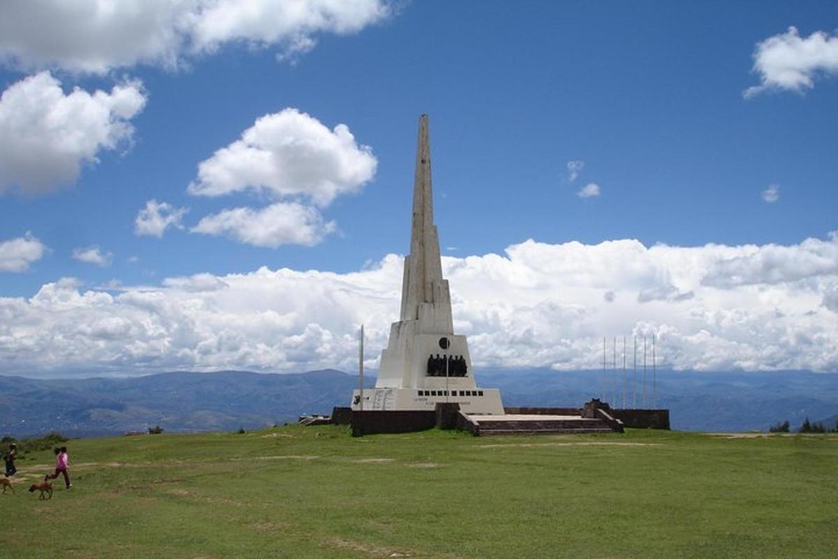 a church steeple on top of a hill with people and a dog