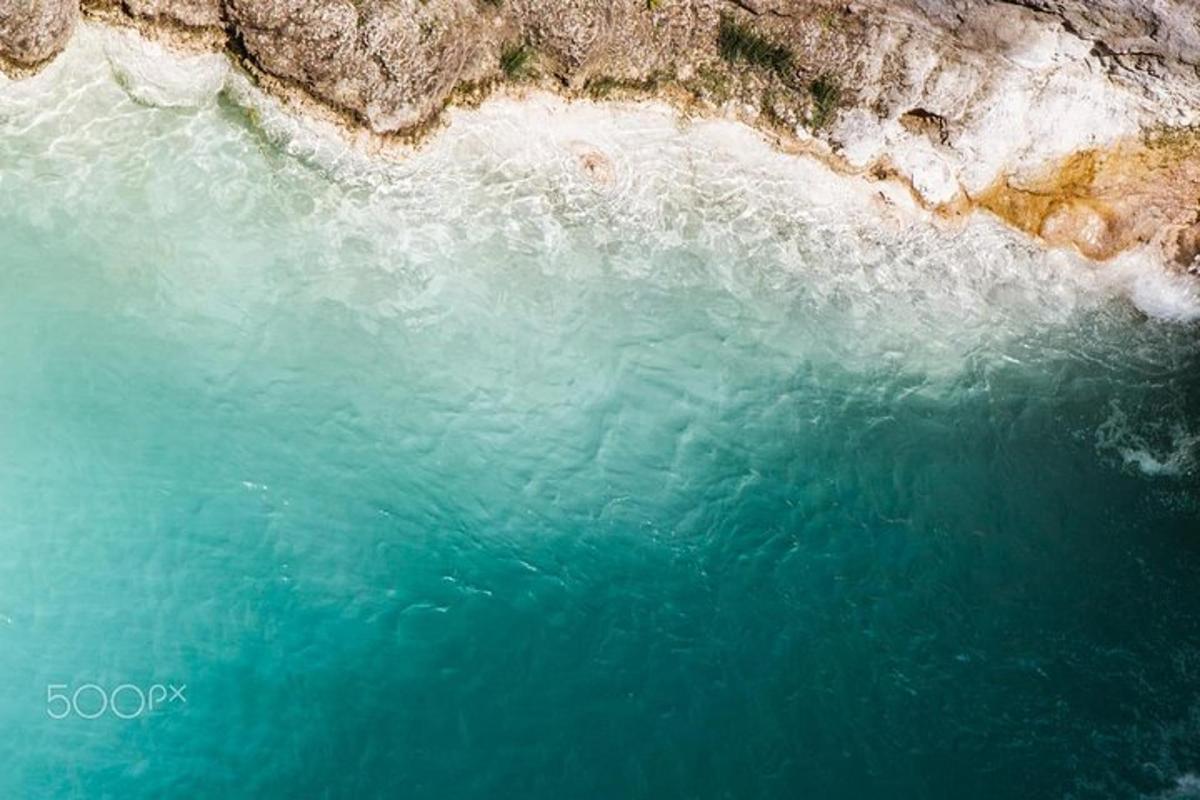 an aerial view of the blue water of a beach