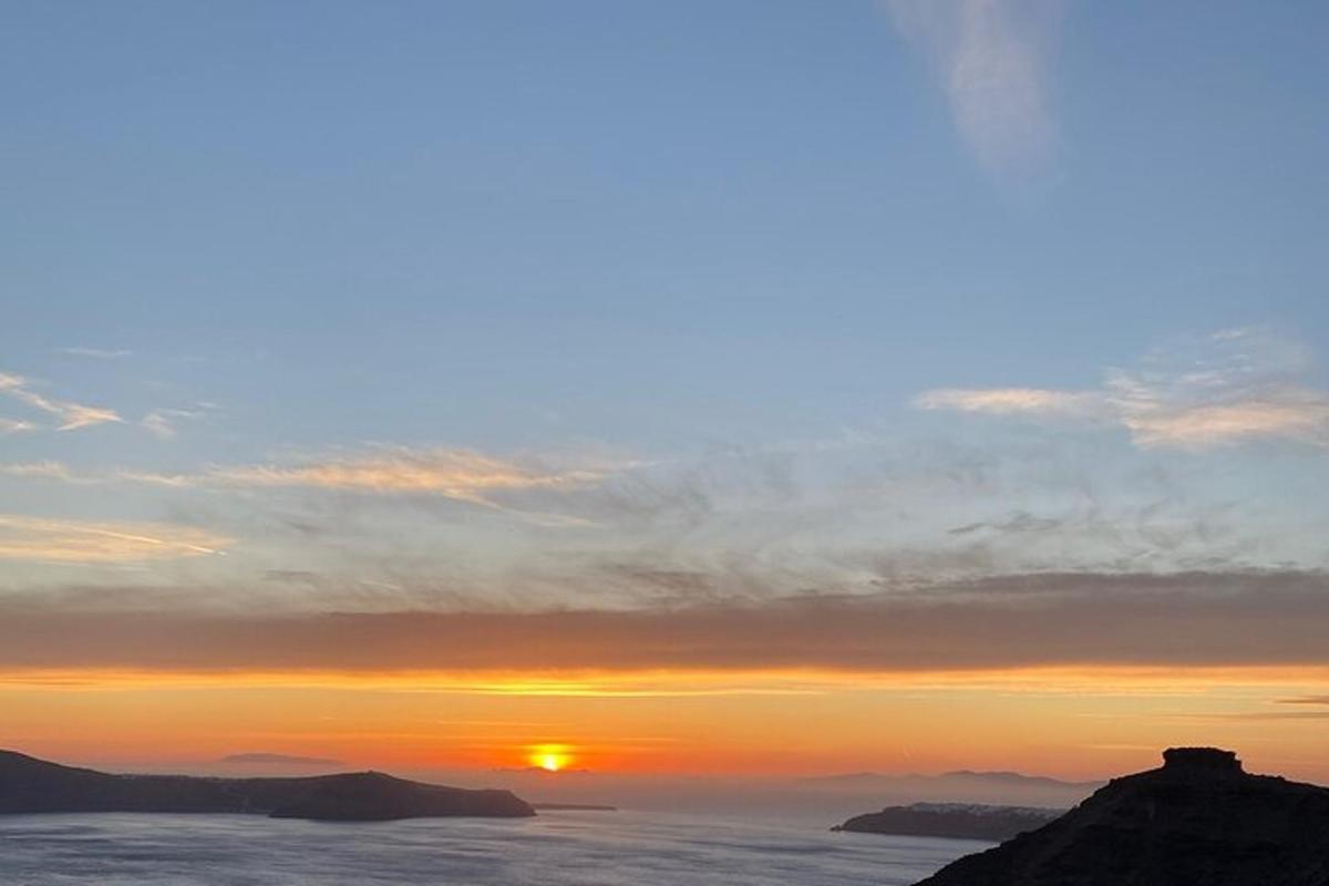 um pôr do sol sobre o oceano com o sol no céu