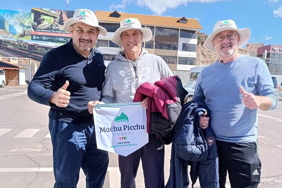 um grupo de três homens segurando uma placa e fazendo sinal de positivo