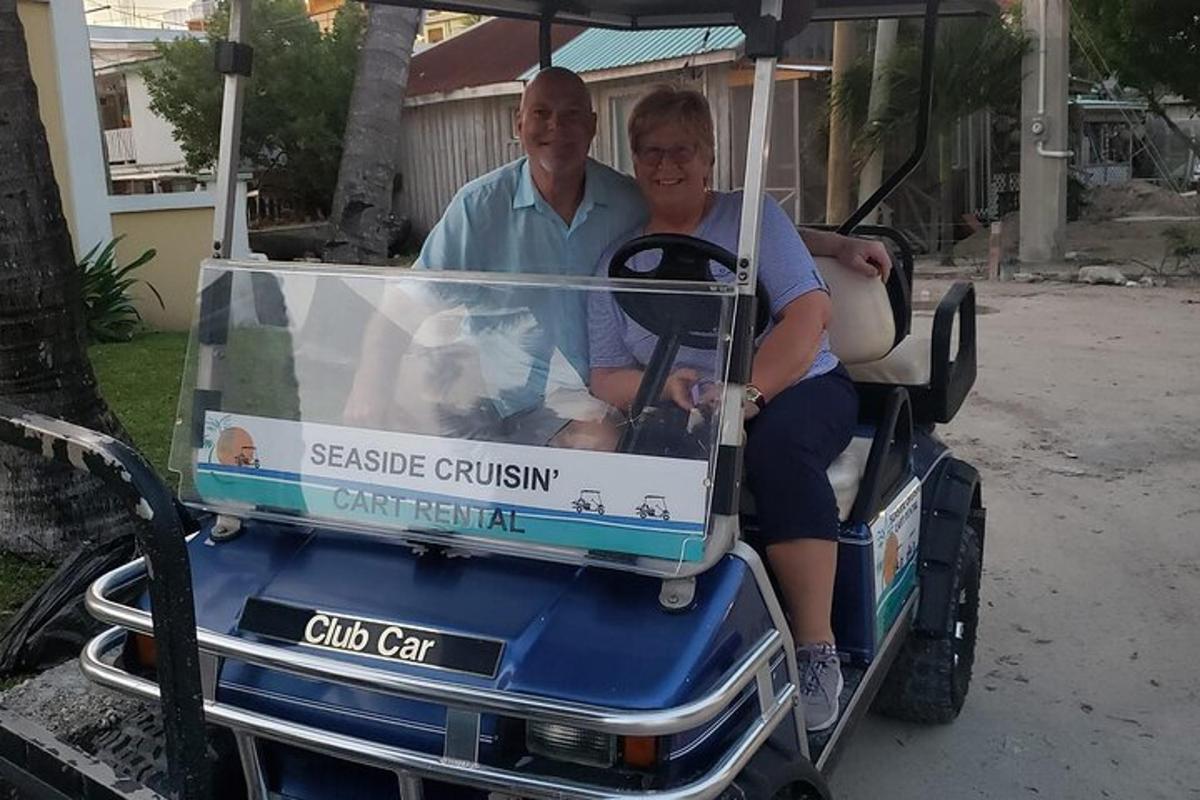 a man and a woman riding a golf cart