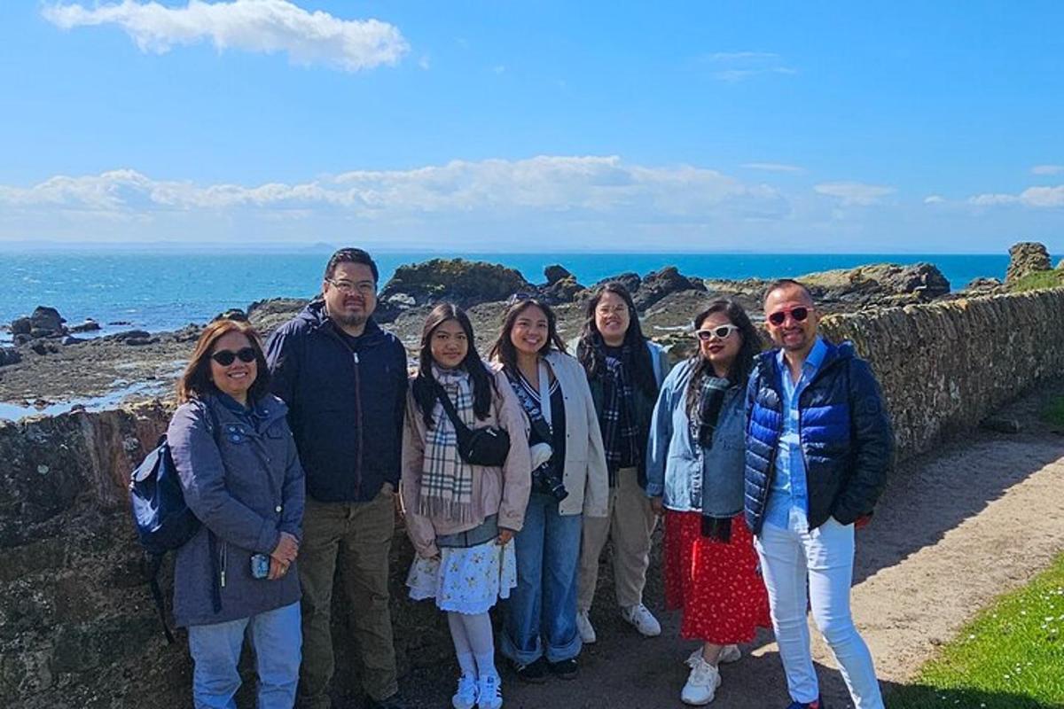 un gruppo di persone in piedi su un muro vicino all'oceano