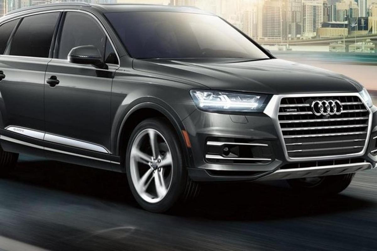 a black audi suv driving down a street