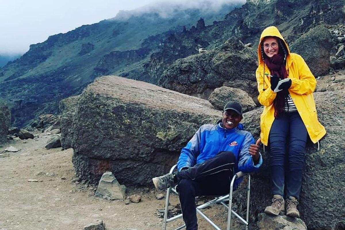 un uomo e una donna seduti su una sedia su una montagna