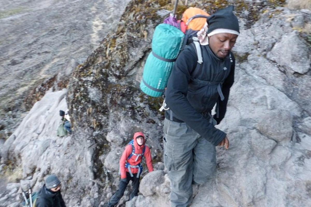 en mann med ryggsekk som går opp et fjell