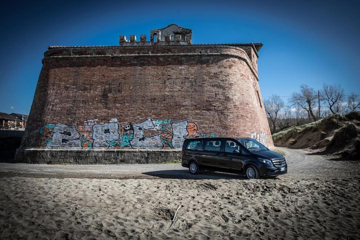 a black van parked next to a wall with graffiti