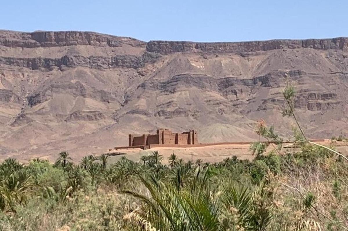 un antic temple al desert amb muntanyes al fons