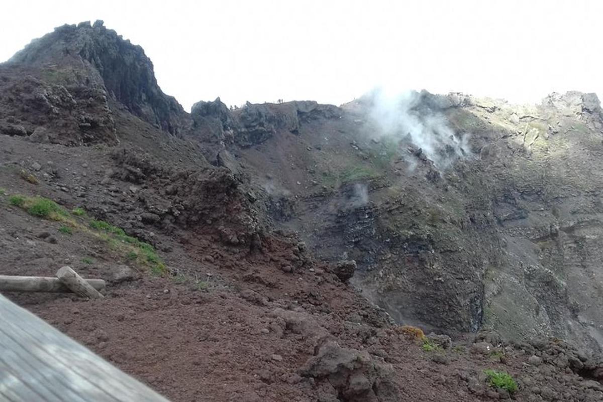 isang bundok na may usok na lumalabas dito sa tabi ng isang kalsada