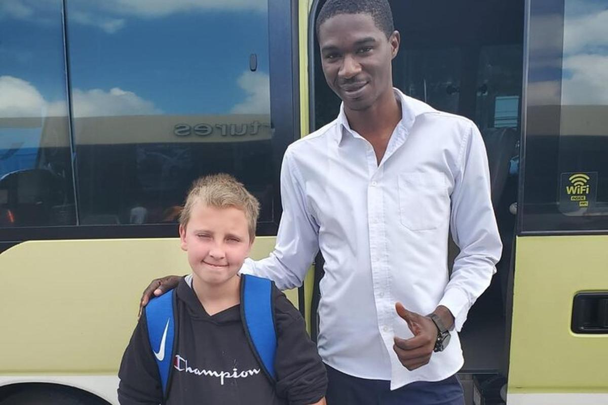 en man som står bredvid en pojke framför en buss