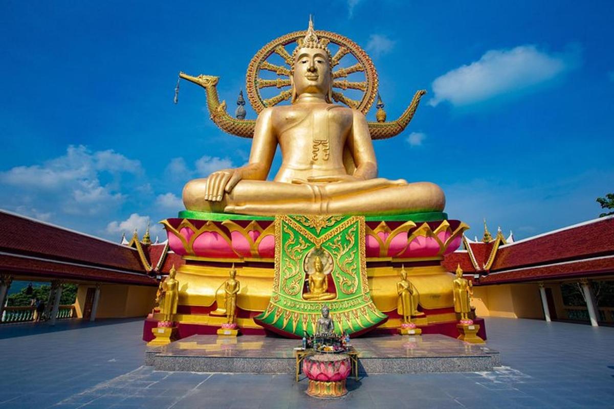 uma grande estátua de Buda dourada em frente a um edifício