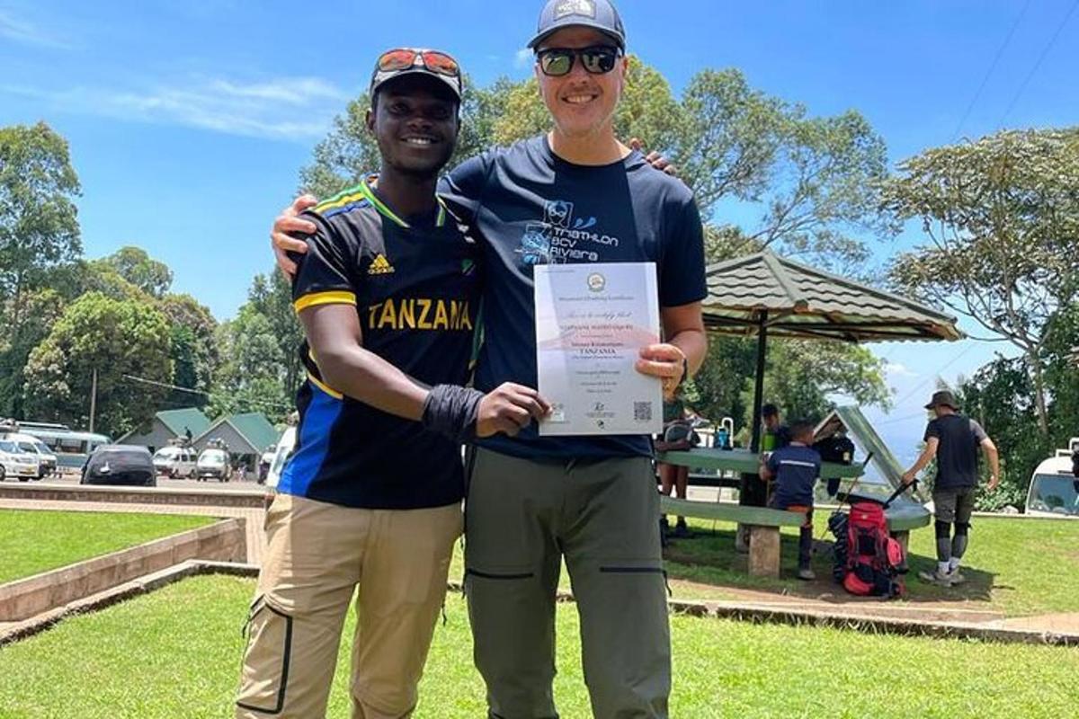 dois homens estão segurando um certificado em um parque