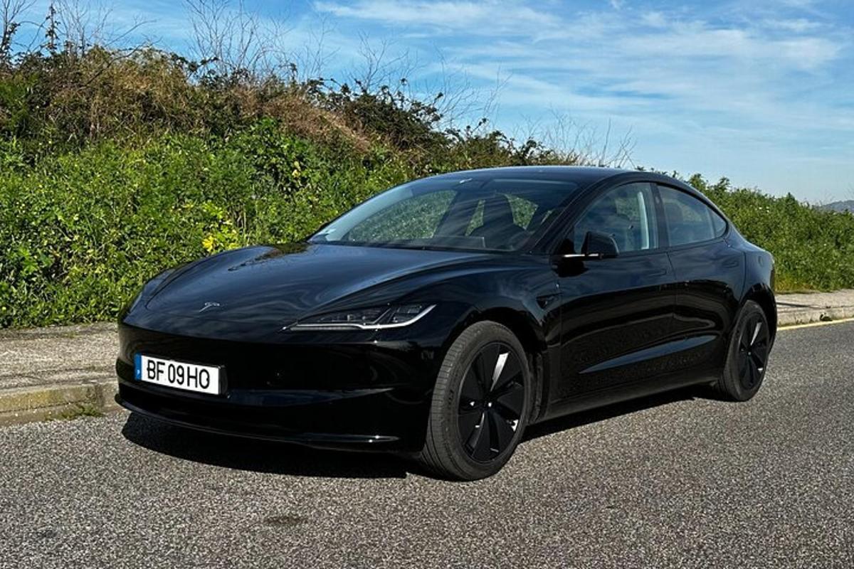 un'auto Tesla nera che percorre una strada