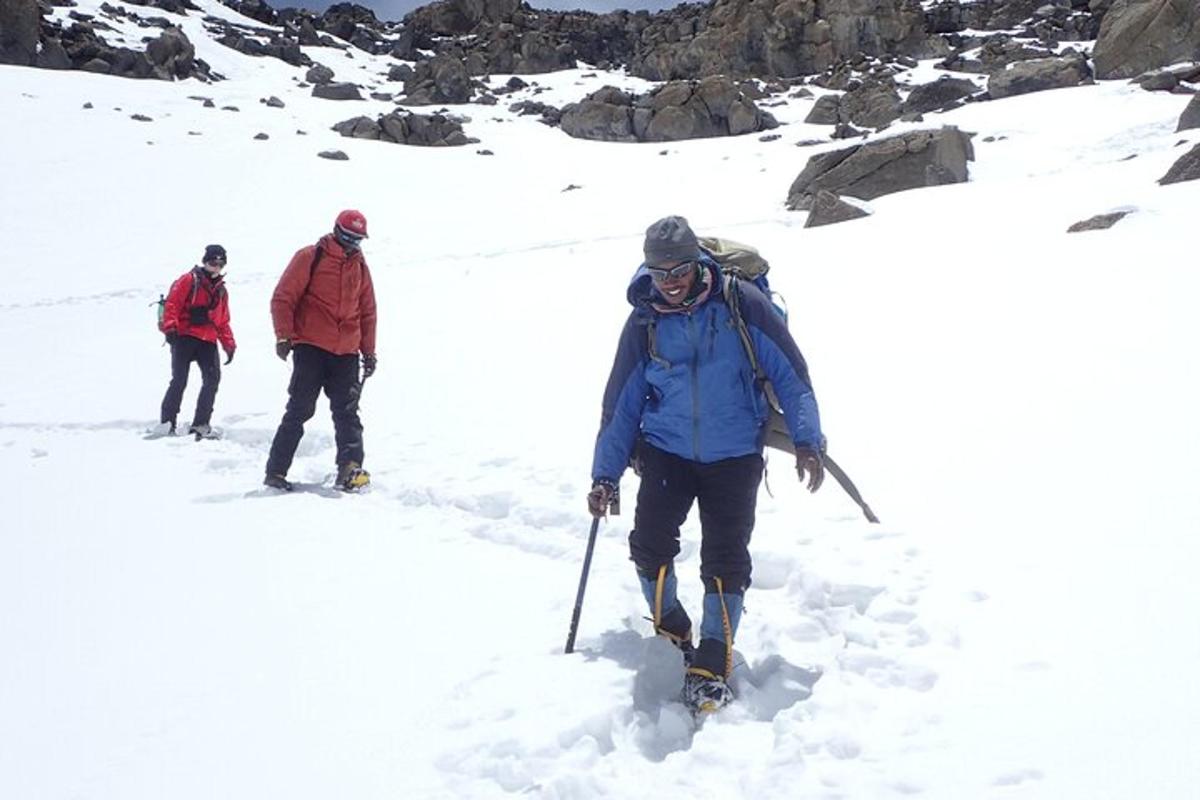 Un grupo de tres personas caminando por la nieve.
