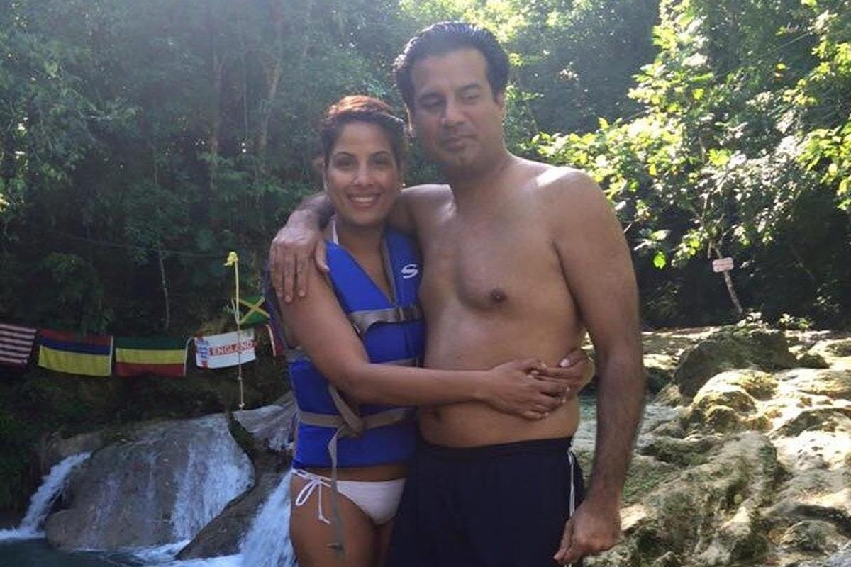 um homem e uma mulher em pé em frente a uma cachoeira