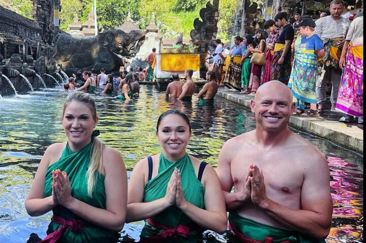 a man and two women standing in the water