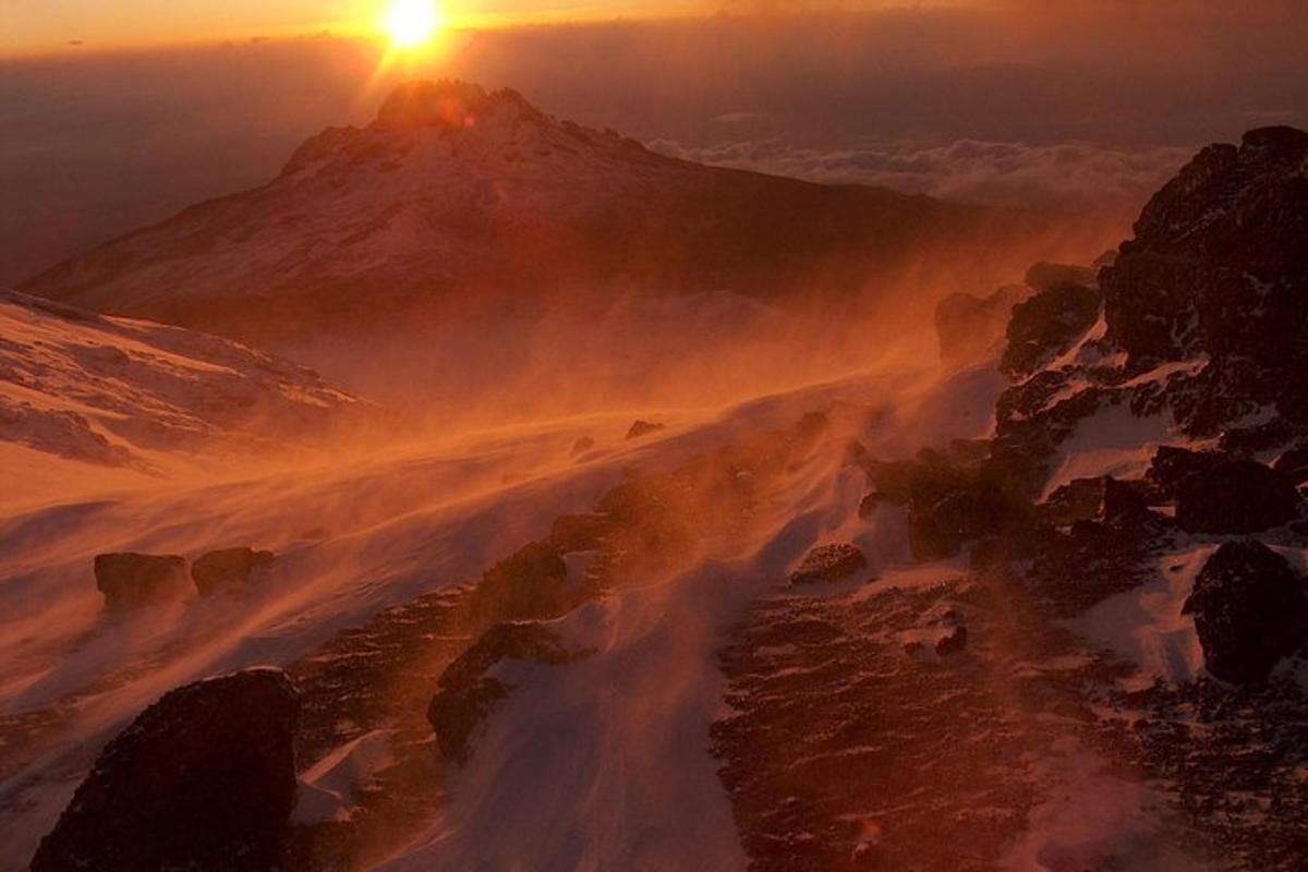una vista di una montagna con il sole che tramonta su di essa