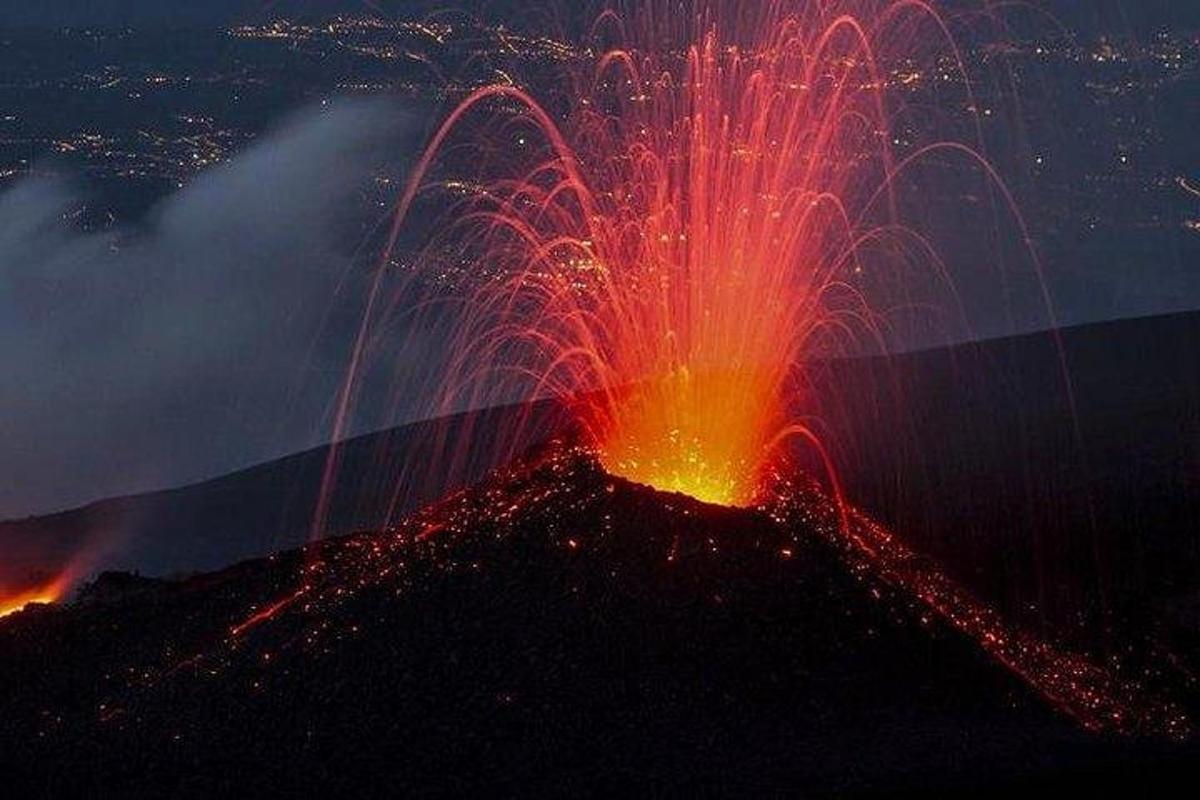 un vulcano con fuochi d'artificio in cima di notte