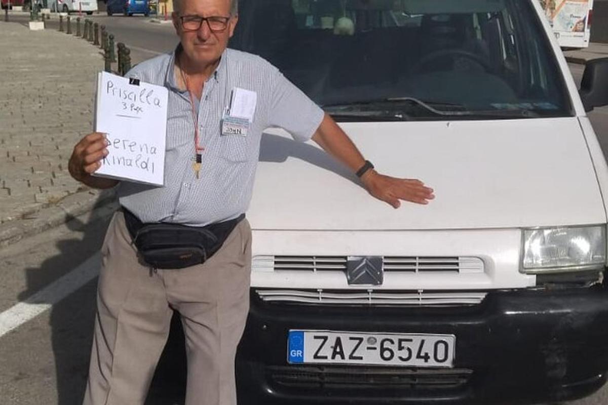 muž držící ceduli před bílou dodávkou