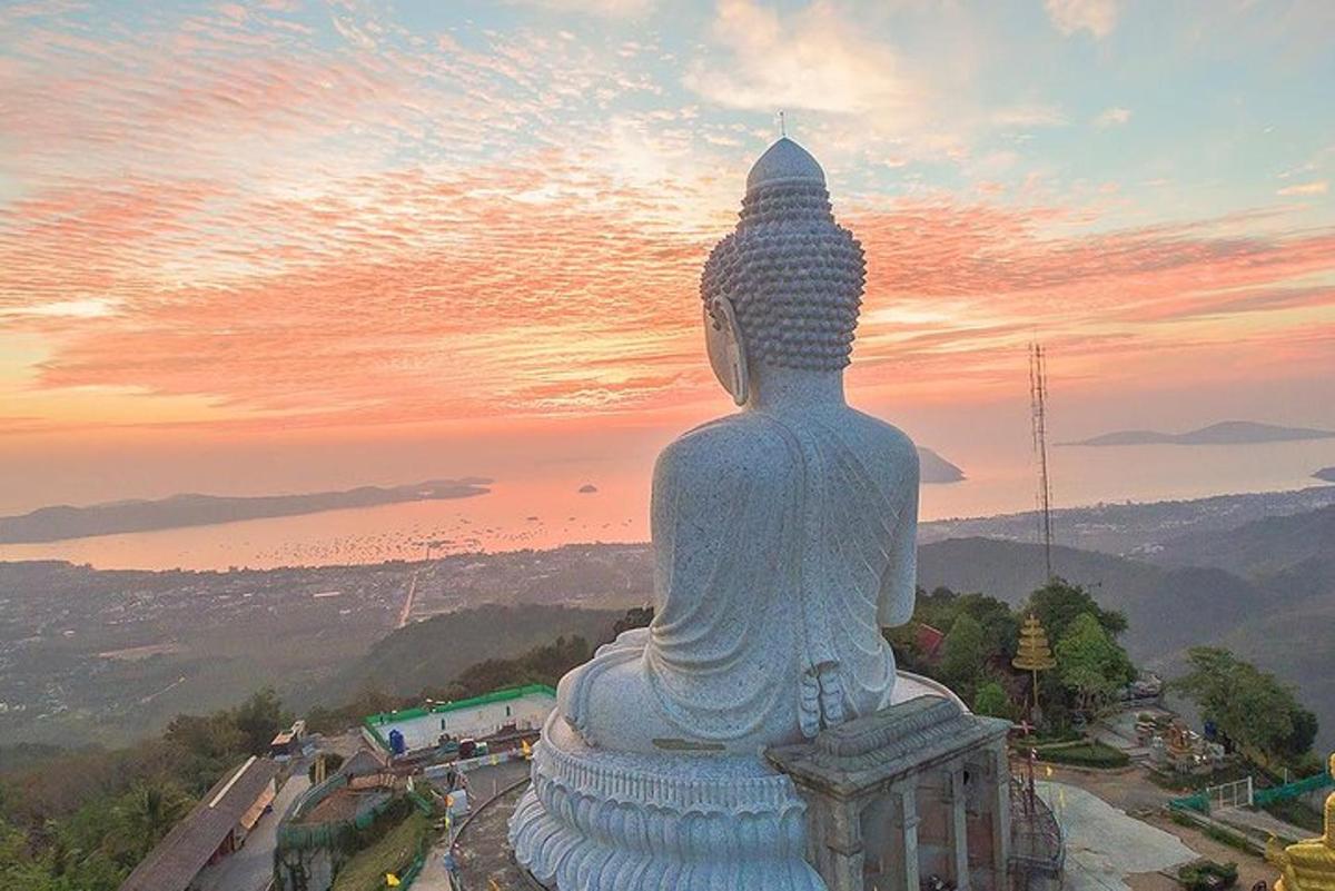 una grande statua seduta in cima a una montagna