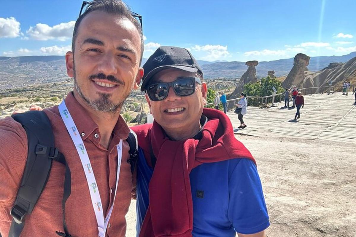 Dos hombres posando para una foto en la cima de una montaña