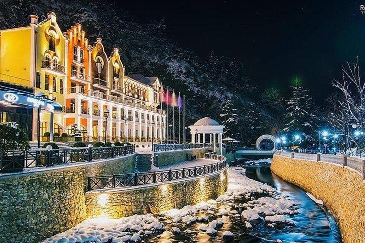 ein Gebäude mit Schnee auf dem Boden neben einem Fluss