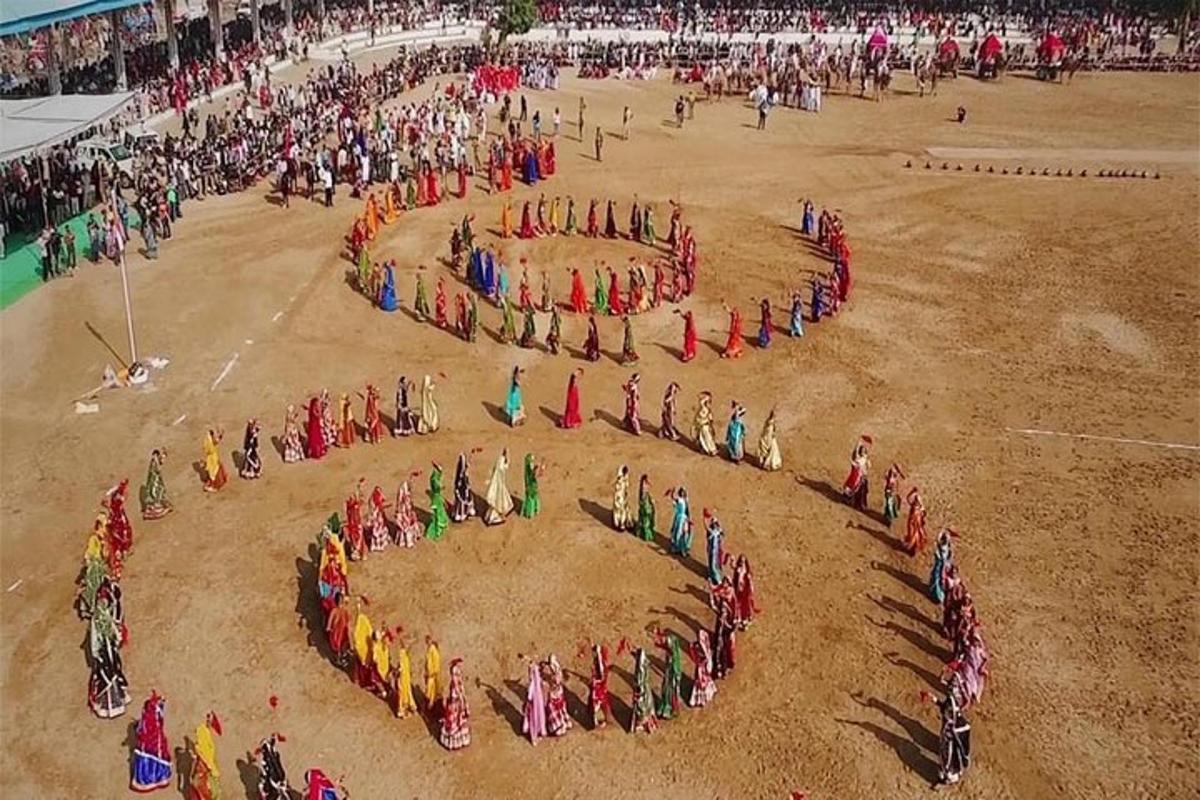 a group of people forming a circle in the dirt