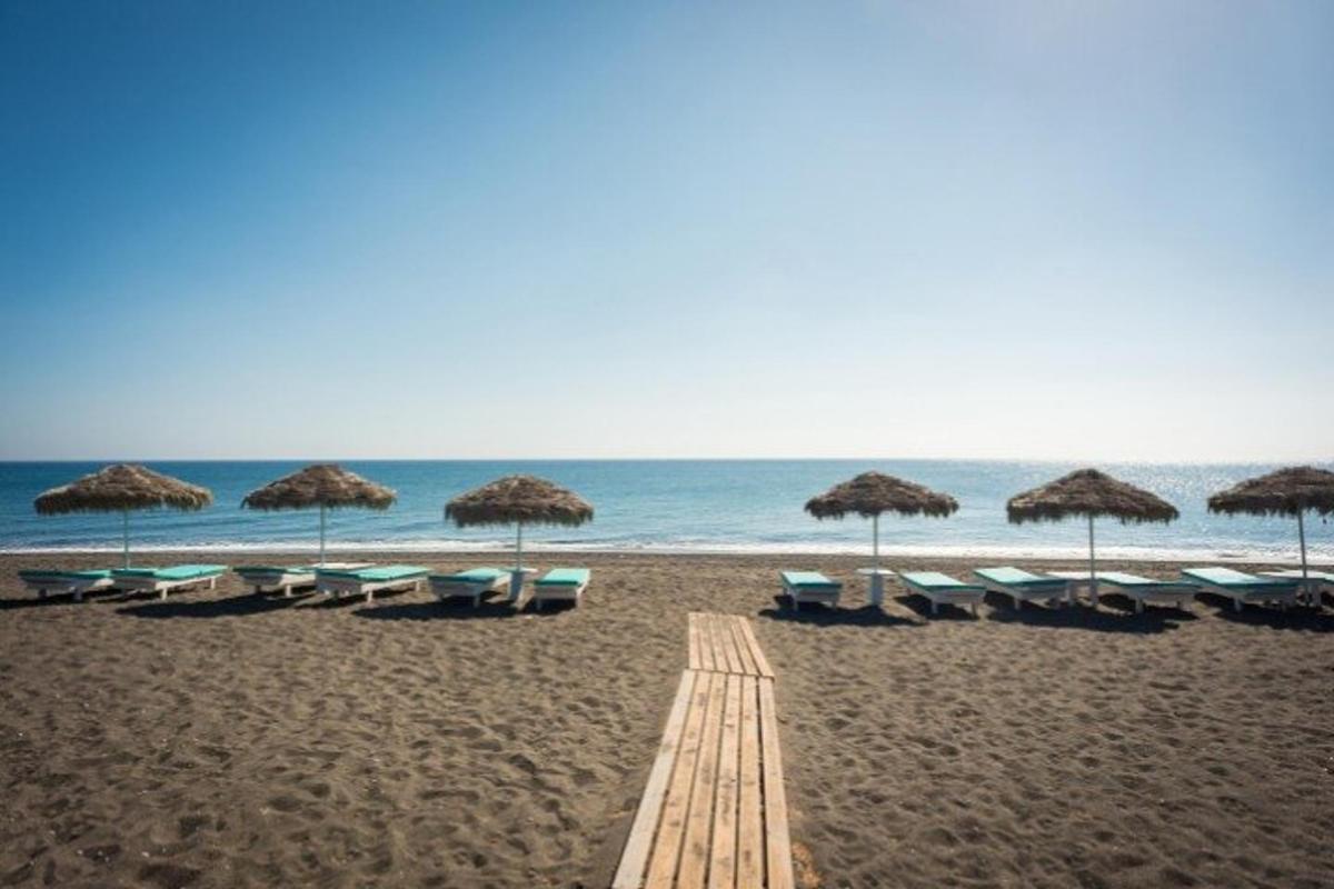 una spiaggia con ombrelloni e sedie e l'oceano