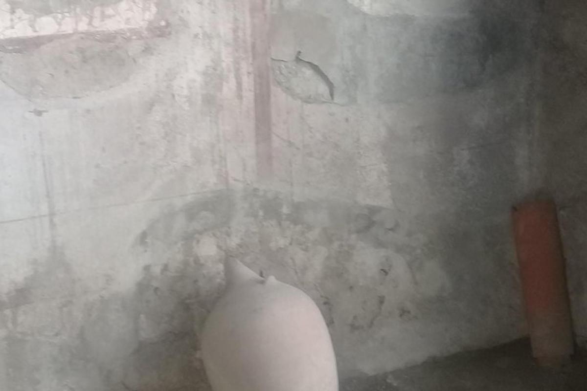 biały wazon stojący przed ścianą