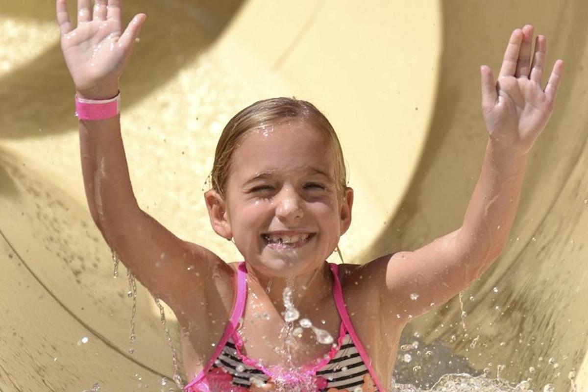 isang batang babae ang naglalaro sa isang water slide