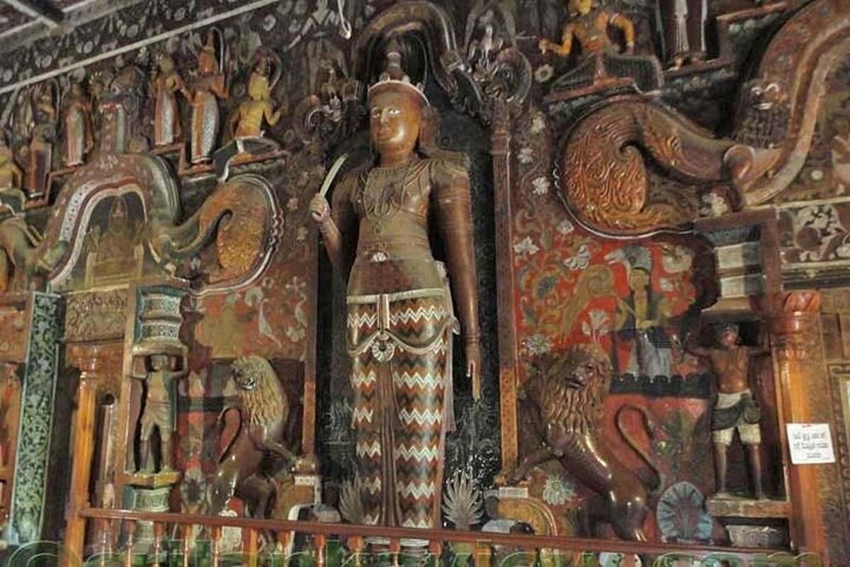 eine Statue einer Frau, die vor einem Wandgemälde steht