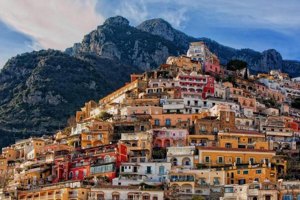 Un montón de casas en una colina con una montaña