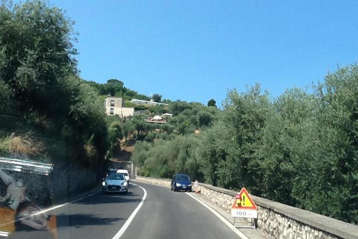 silnice s auty a cedulí na kraji