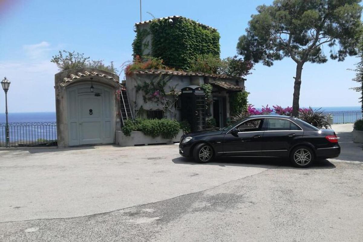 ein schwarzes Auto, das vor einem Haus geparkt ist