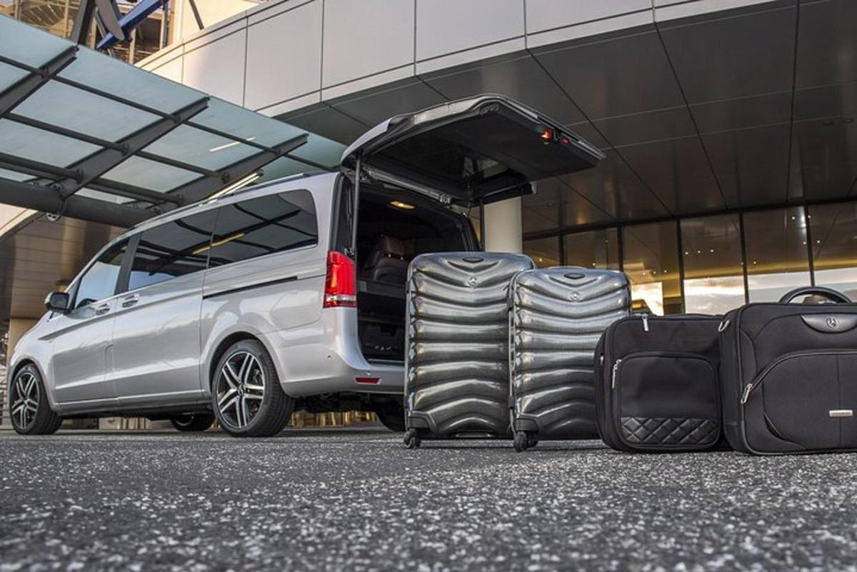 two pieces of luggage sitting in front of a van