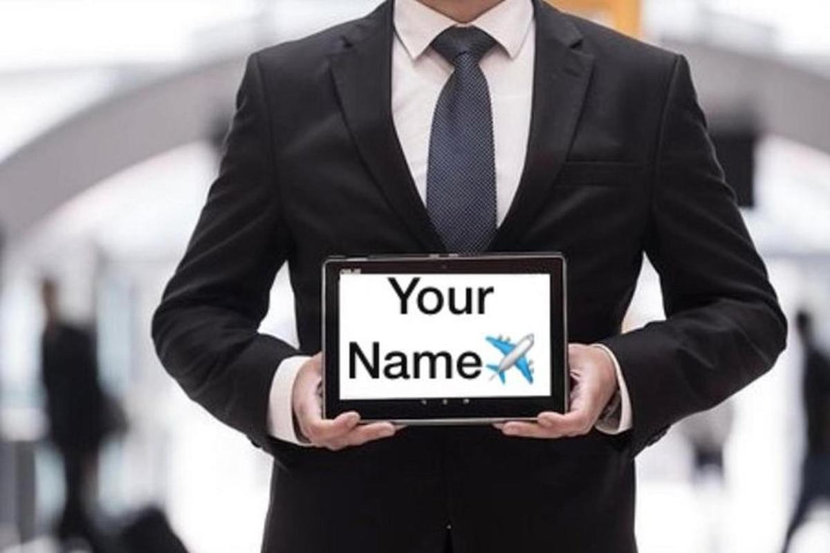 a man in a suit holding a tablet with your name on it