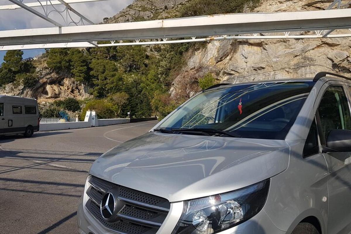 Una camioneta blanca estacionada en una carretera junto a una montaña