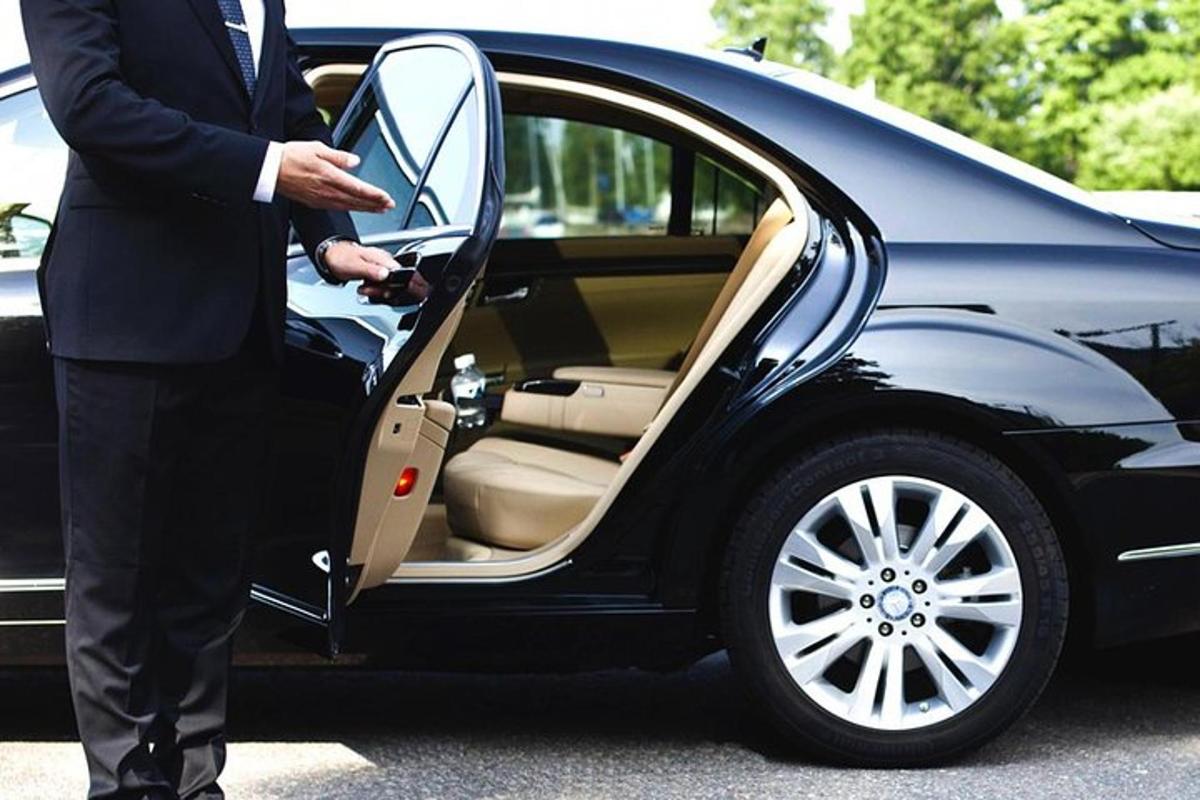 ein Mann im Anzug öffnet die Tür eines Autos