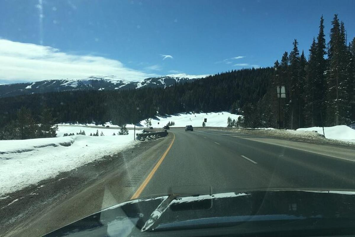um carro dirigindo por uma estrada na neve