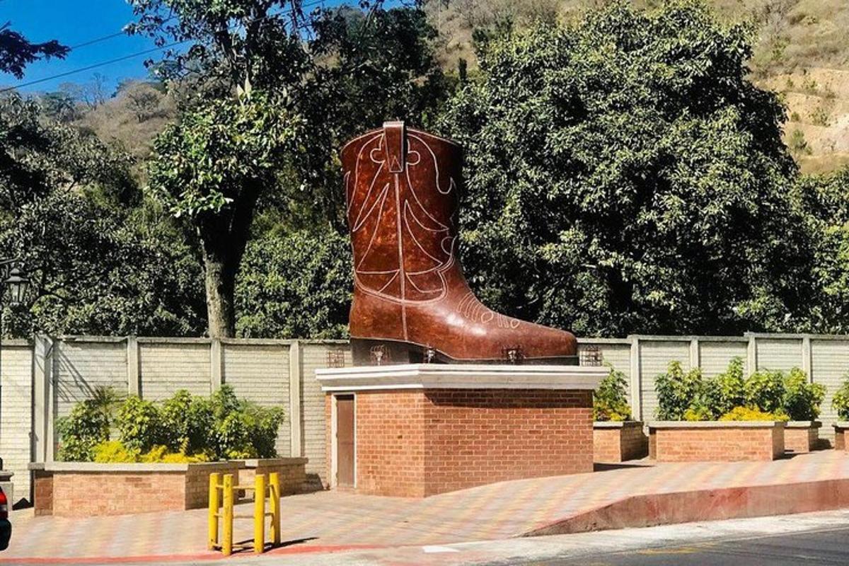 a large brown boot statue sitting on top of a brick wall