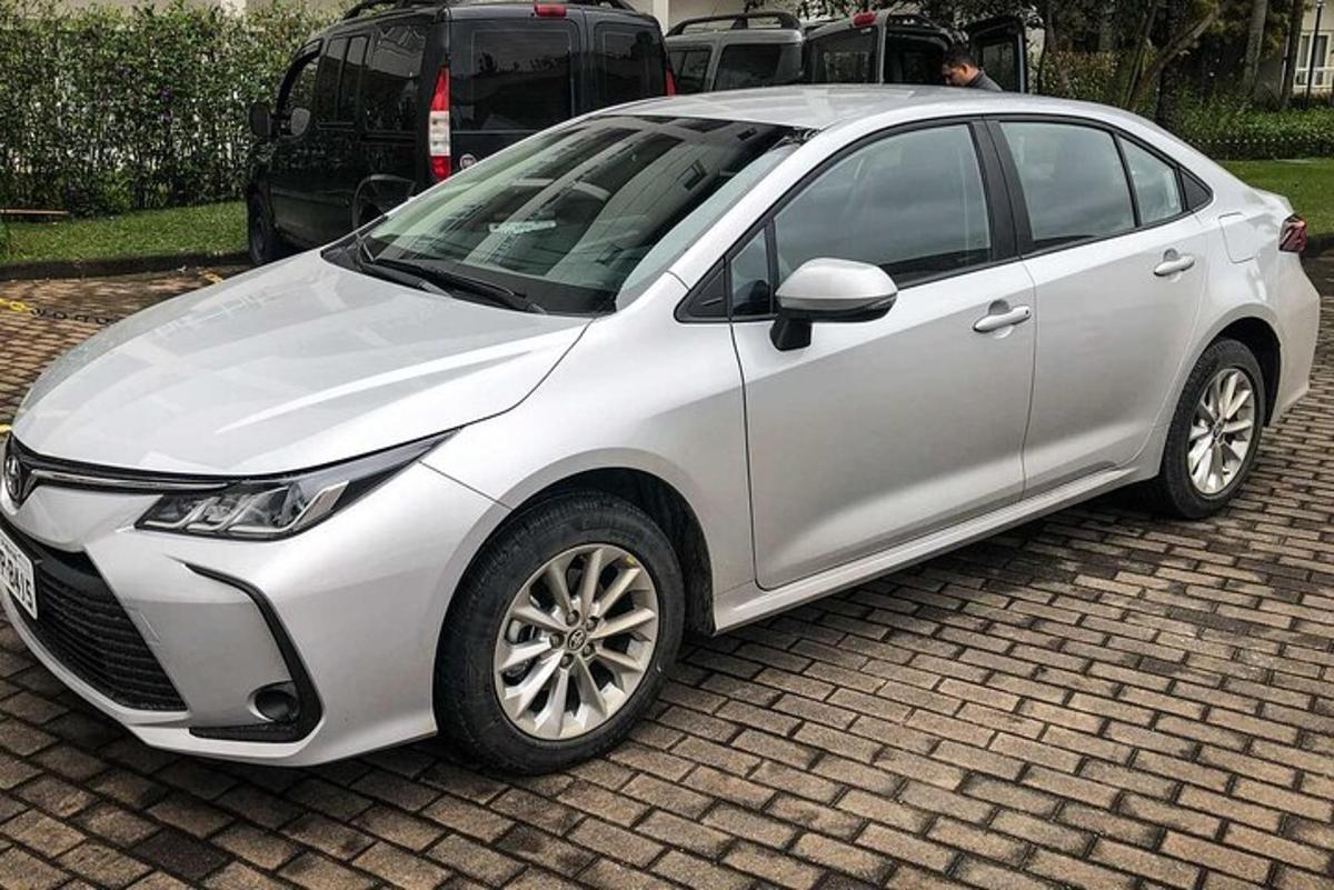bílé auto zaparkované na cihlovém parkovišti
