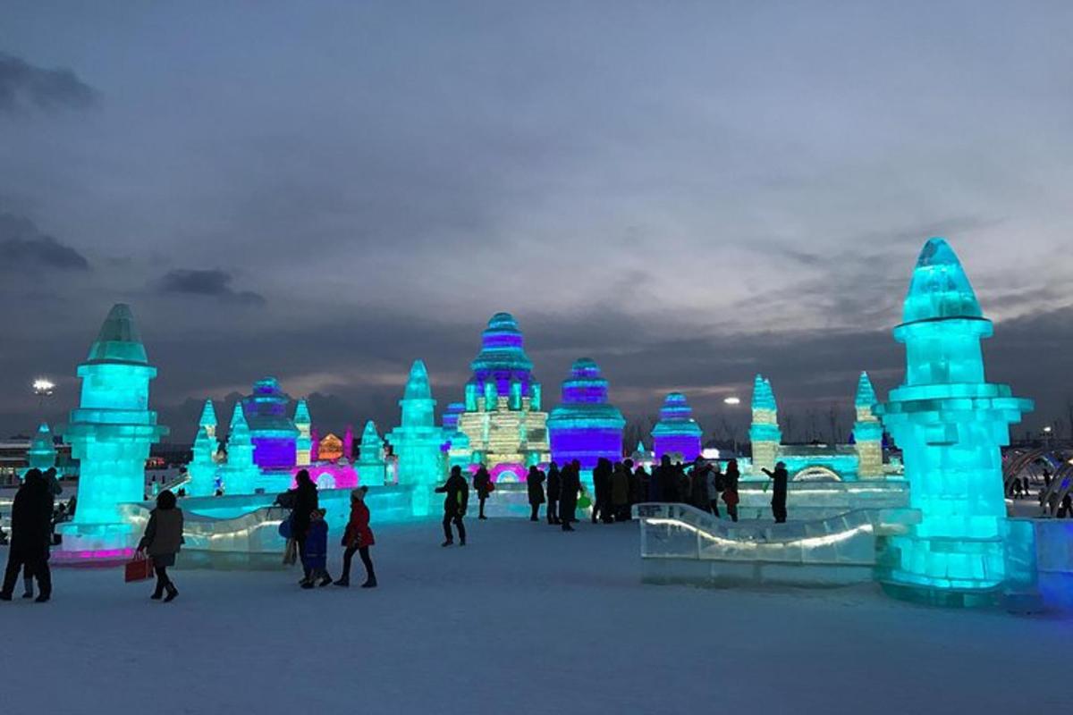 a group of people walking around an ice sculpture