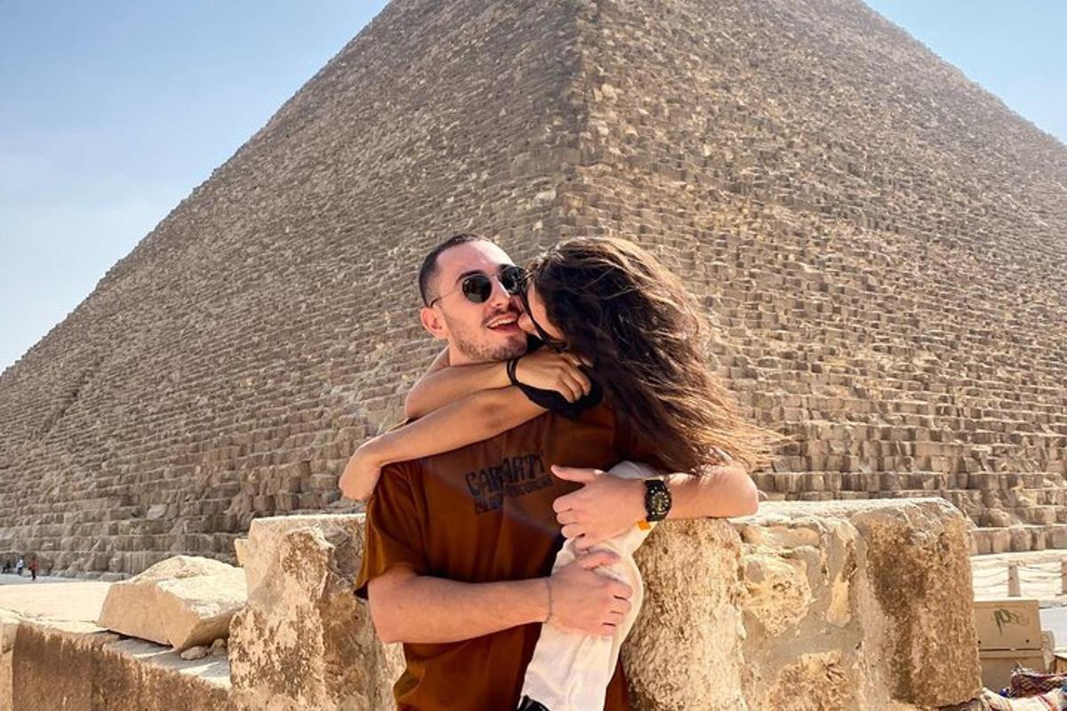 muž a žena stojící před pyramidou