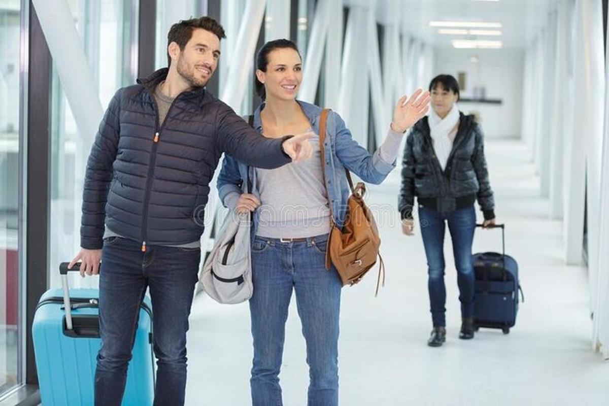 một người đàn ông và một người phụ nữ đang đi bộ trong sân bay với bàn tay đưa ra