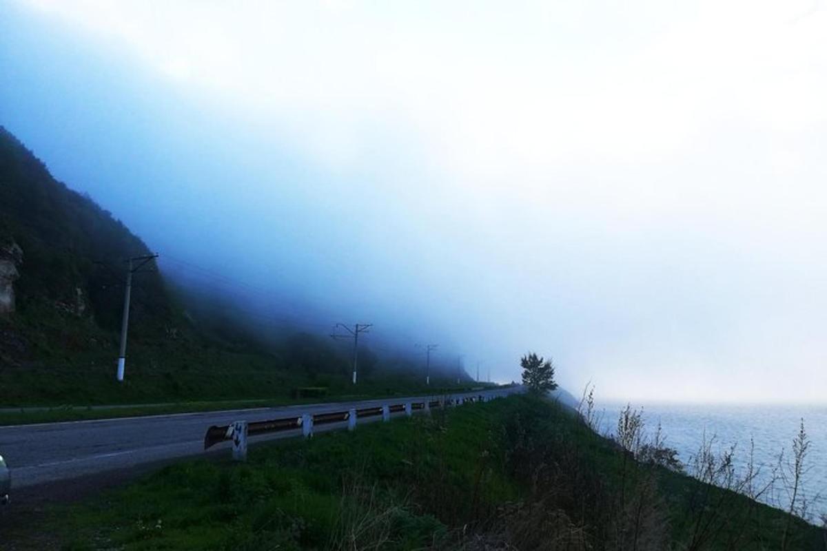 eine Straße mit Nebel an der Seite eines Berges