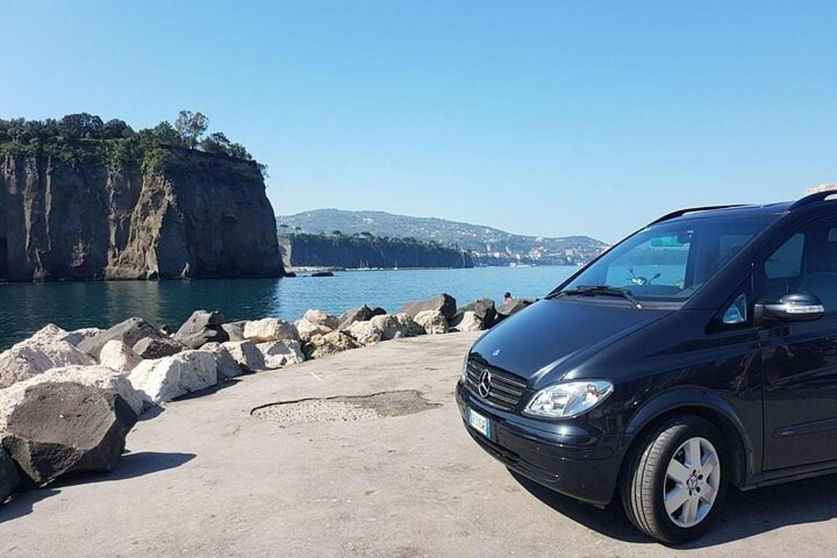 una furgoneta negra aparcada al costat d'una massa d'aigua