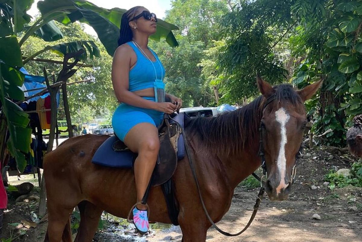 a woman in a blue top sitting on a horse