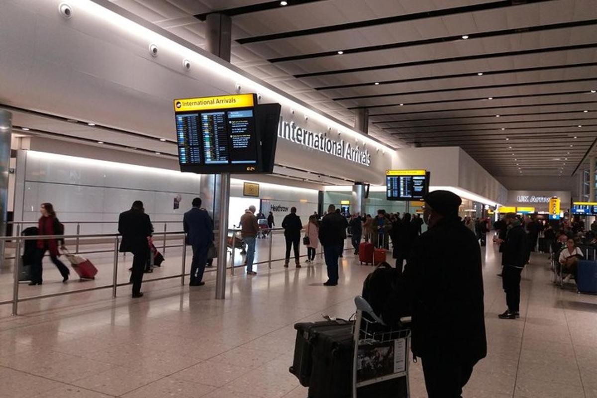 un grup de persones caminant per un aeroport amb equipatge